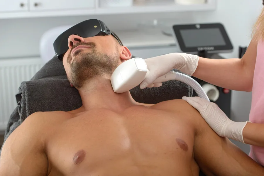 Man receiving laser hair removal treatment on his neck